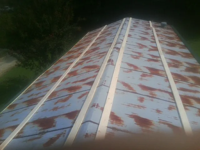 Rusted metal roof panels with new wood purlins before replacement — Storm Damage Roof Repair in Tintah by Roofing Brothers