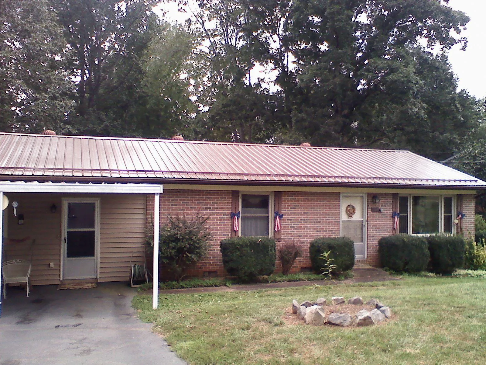Bronze metal roof and carport on a brick ranch home — Roof Repair work by our crew in Tintah